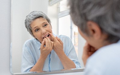 Woman flossing in bathroom