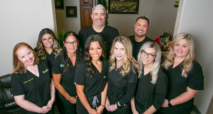 Dental team smiling inside of dental office