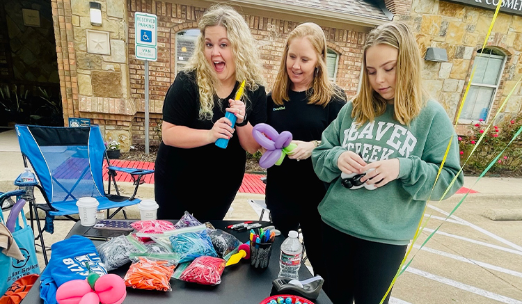 Three dental team members making balloon animals