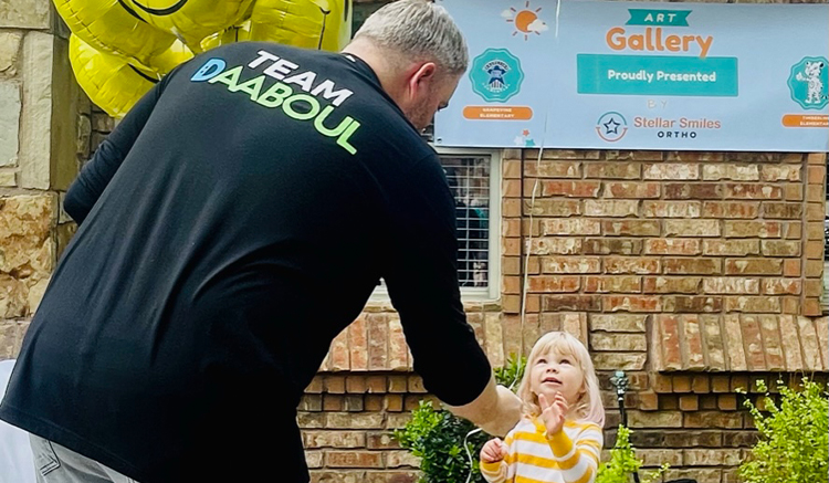 Doctor Daaboul handing a balloon to a child