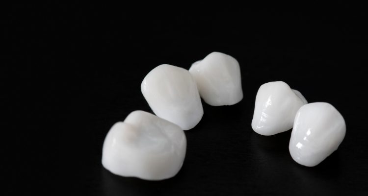 Several metal free dental crowns against black background