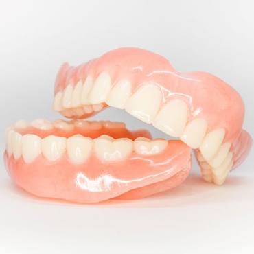 Close-up of full dentures against neutral backdrop