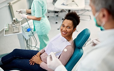 Dentist talking to smiling patient in treatment room