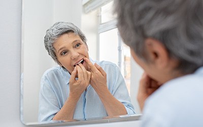 Woman flossing in bathroom