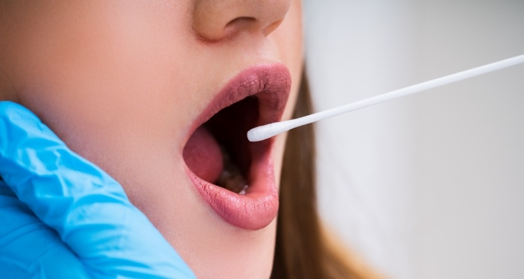 Close up of woman getting mouth swabbed by dentist