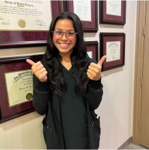 Smiling dental team member giving two thumbs up