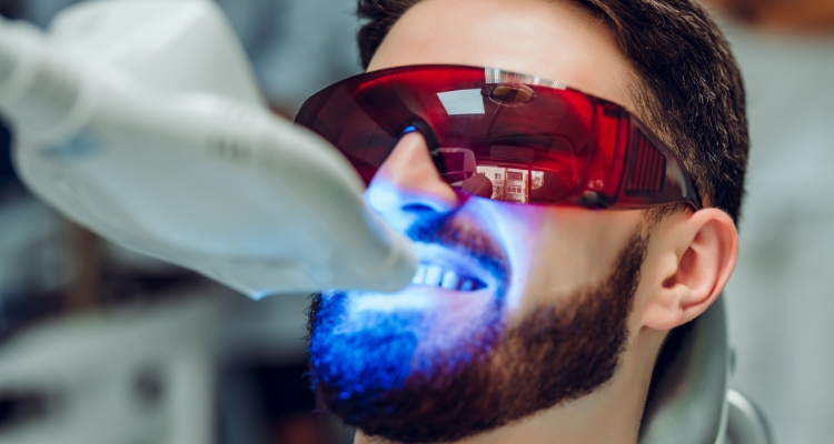 Man getting professional teeth whitening in dental office