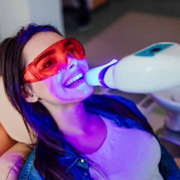 Smiling woman getting in office teeth whitening