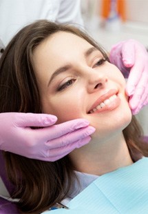 patient smiling while looking in dental mirror 