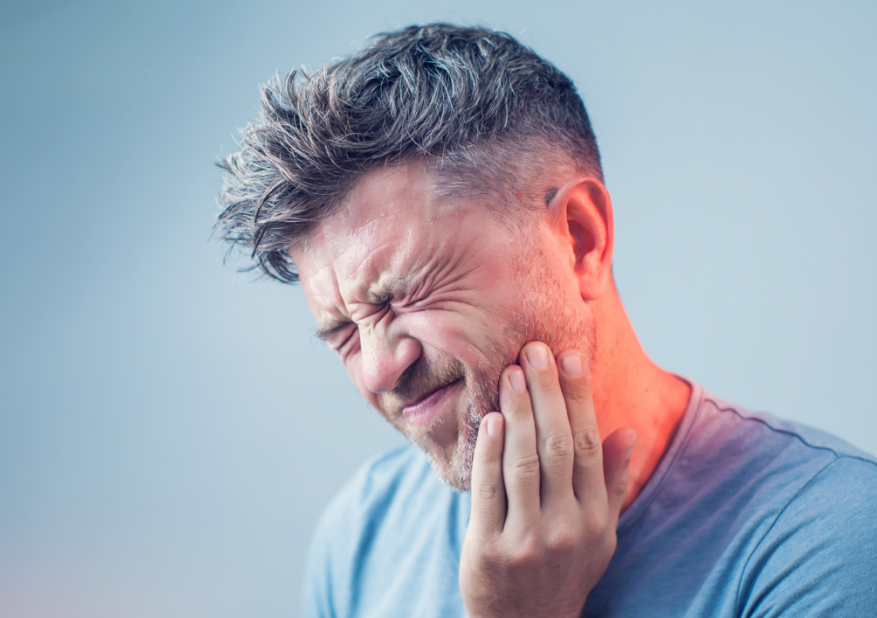 Man holding jaw in pain