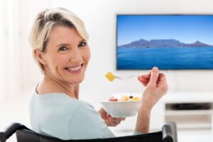 Woman with dentures eating cut fruit